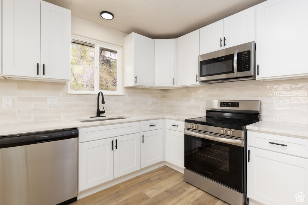 Kitchen with stainless steel appliances, light countertops, and a sink