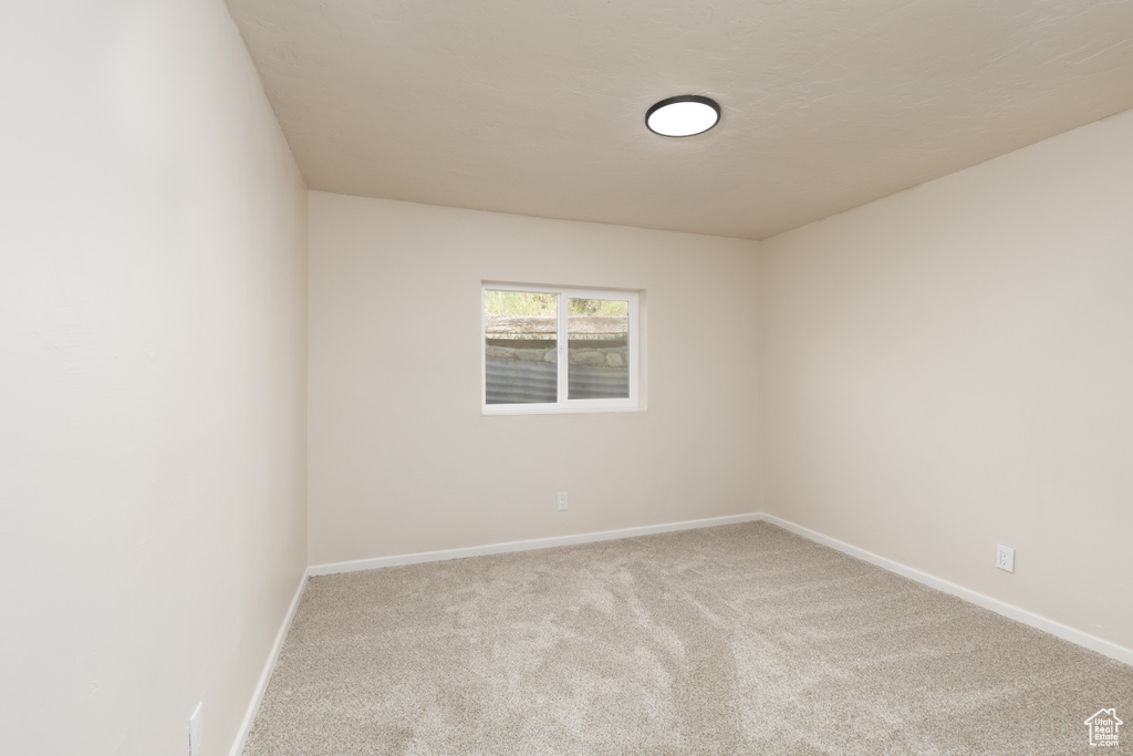 Empty room featuring carpet and baseboards