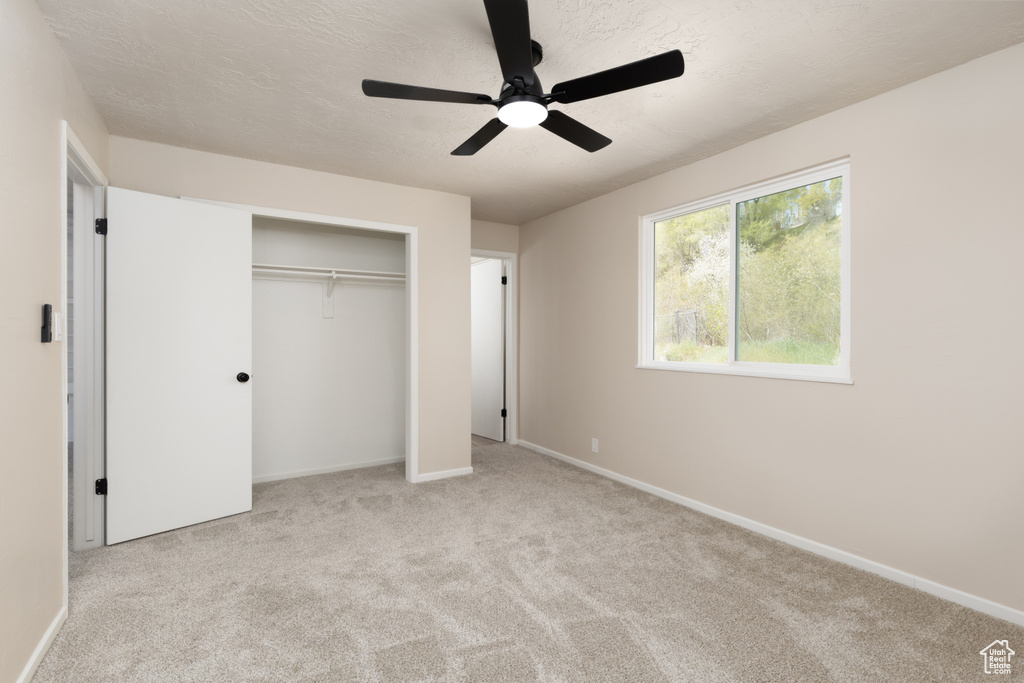 Unfurnished bedroom featuring ceiling fan, baseboards, carpet flooring, and a closet