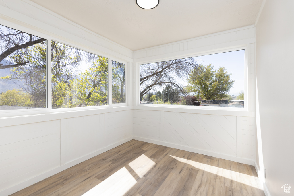 Unfurnished sunroom with wood finished floors