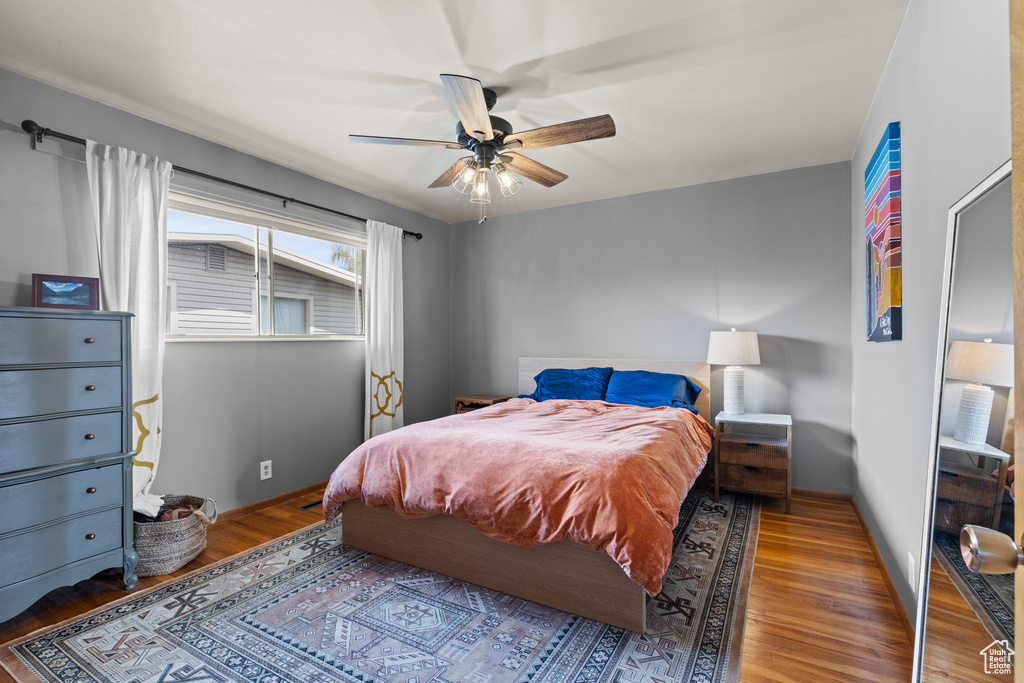Bedroom featuring baseboards, ceiling fan, and wood finished floors