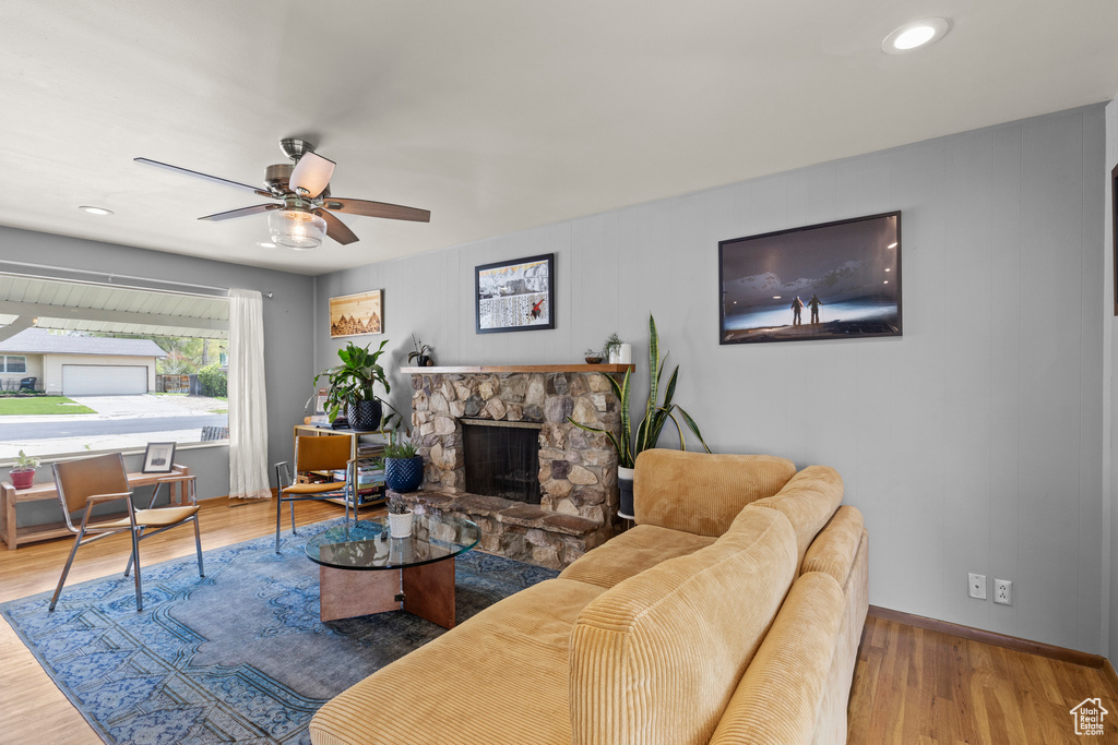 Living area featuring ceiling fan, a fireplace, wood finished floors, baseboards, and recessed lighting