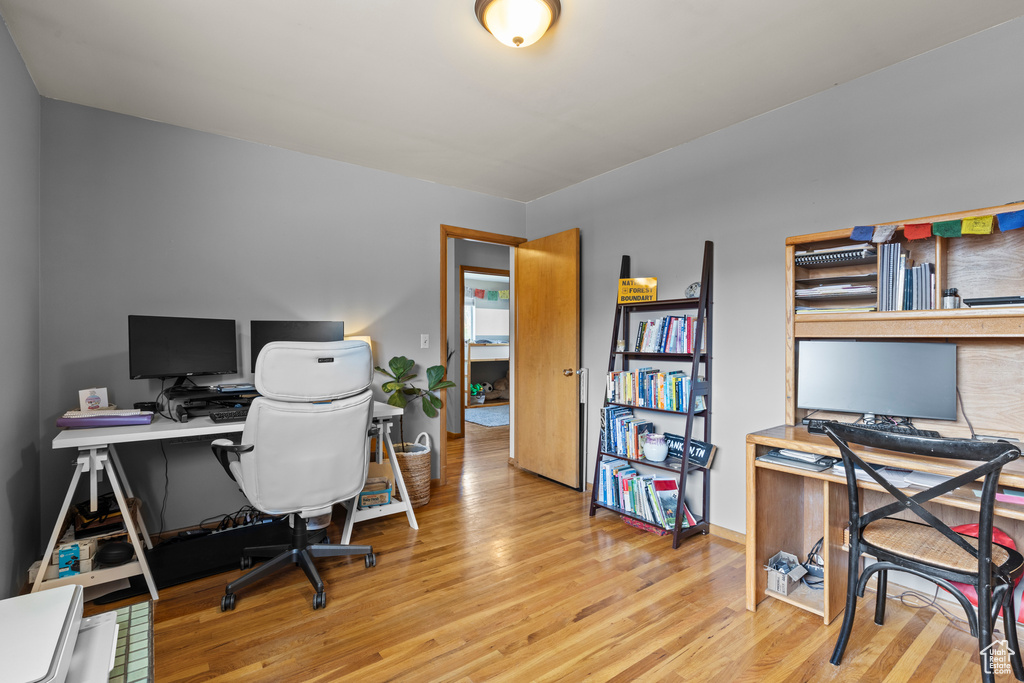 Office space with baseboards and wood finished floors