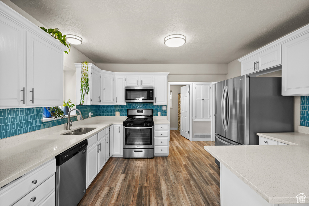 Kitchen featuring light countertops, stainless steel appliances, and a sink