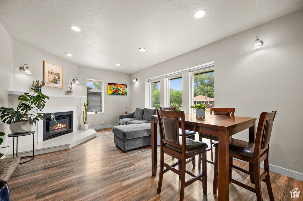 Dining area featuring recessed lighting, a glass covered fireplace, wood finished floors, and baseboards