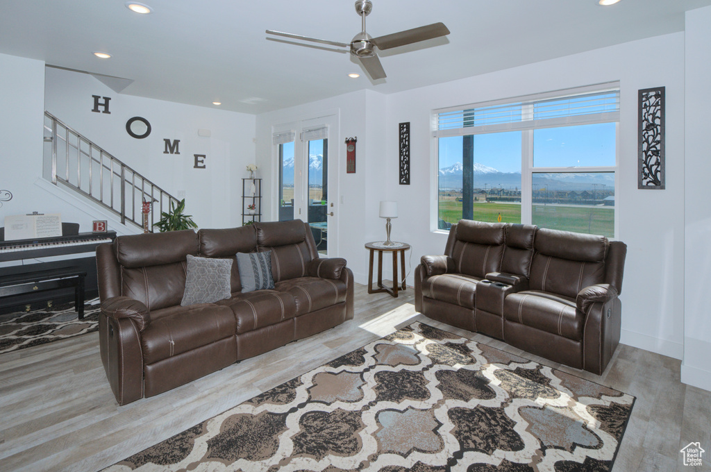 Living area with stairway, a ceiling fan, wood finished floors, and recessed lighting