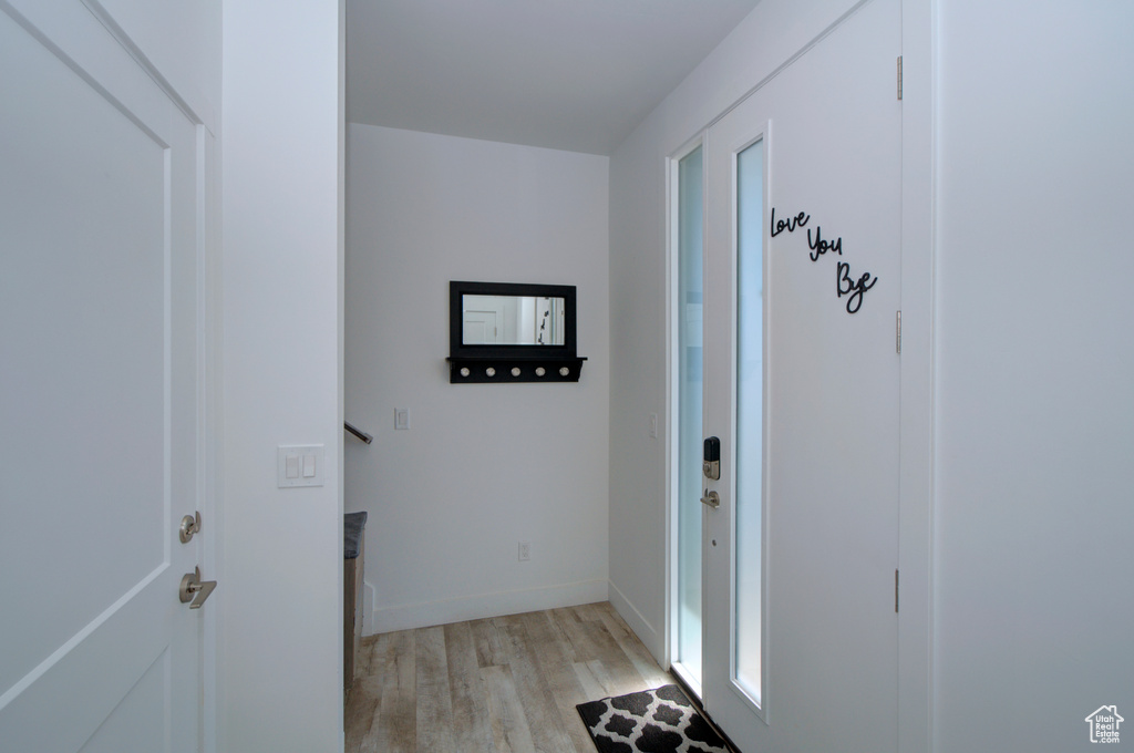 Doorway to outside featuring light wood-style floors and baseboards