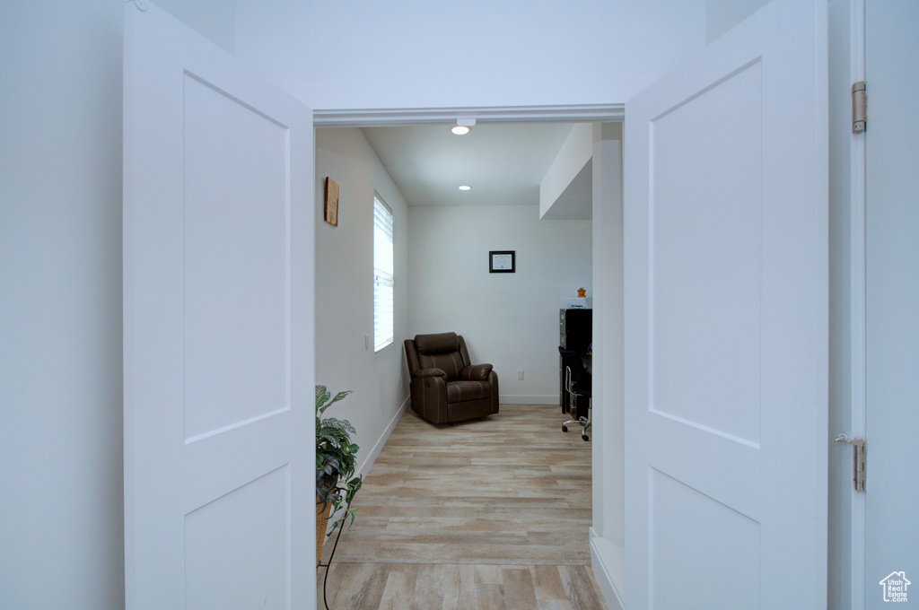 Corridor with light wood finished floors, baseboards, and recessed lighting