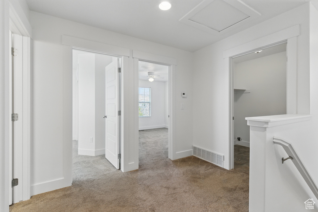 Hall with visible vents, carpet flooring, and baseboards