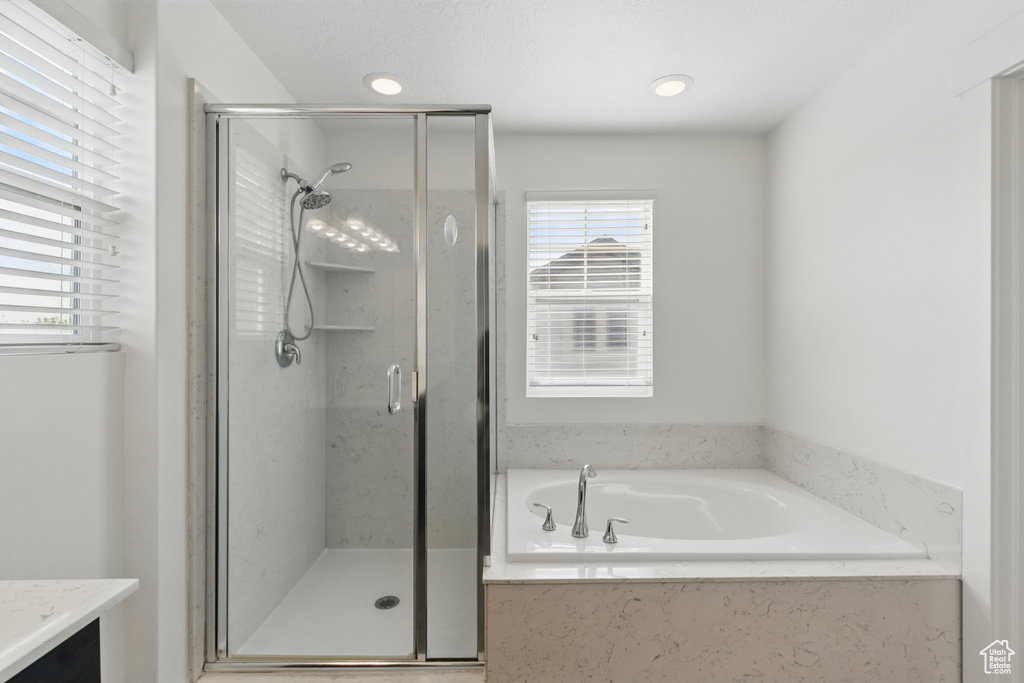 Full bathroom with a garden tub, vanity, and a shower stall