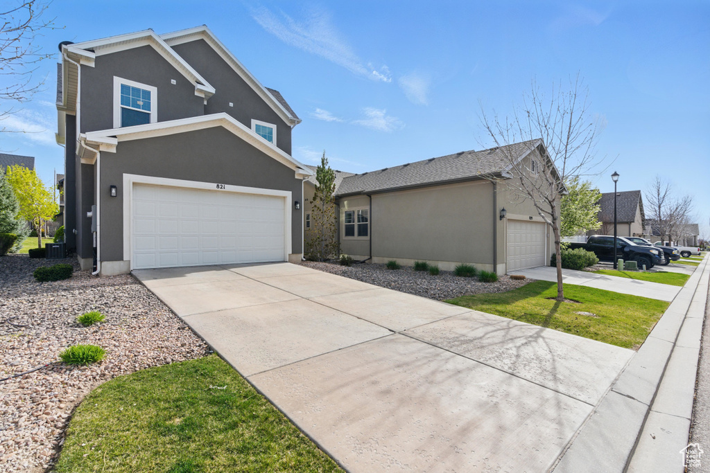View of front facade with stucco siding and concrete driveway
