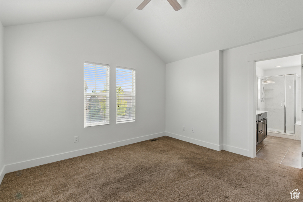 Unfurnished bedroom featuring vaulted ceiling, baseboards, light colored carpet, ceiling fan, and connected bathroom