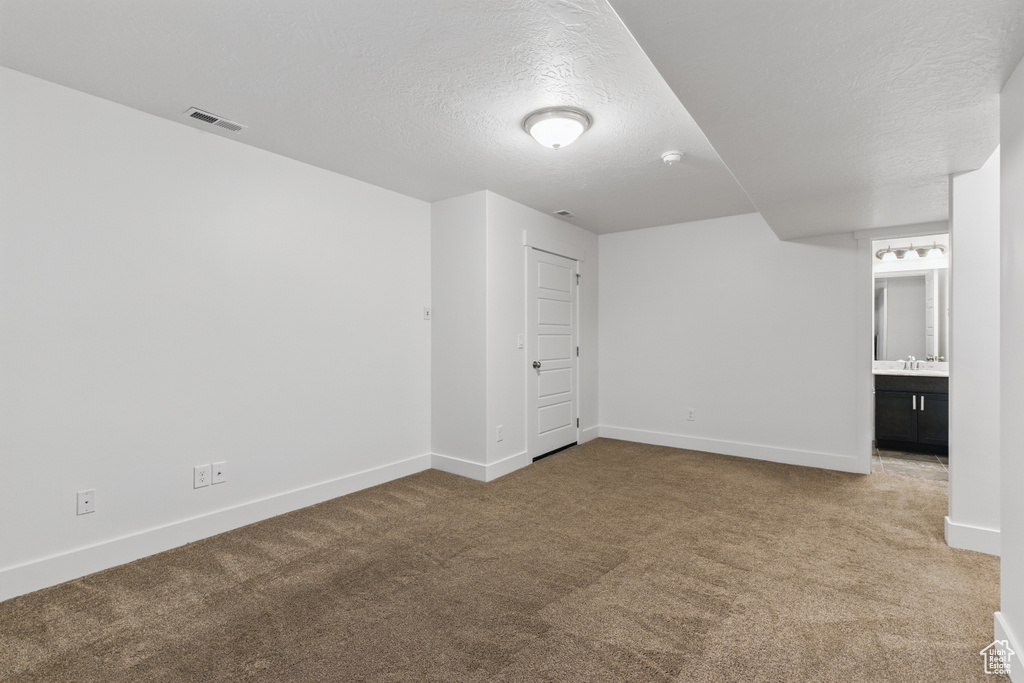 Unfurnished bedroom with visible vents, baseboards, carpet, and a textured ceiling