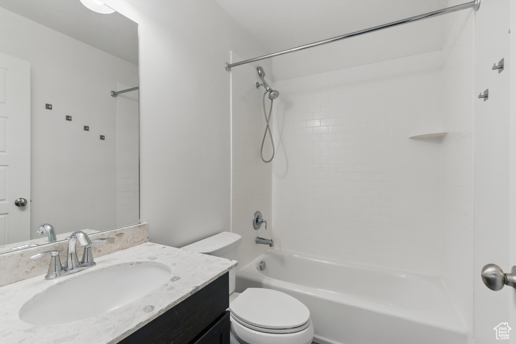 Bathroom with toilet, vanity, and washtub / shower combination