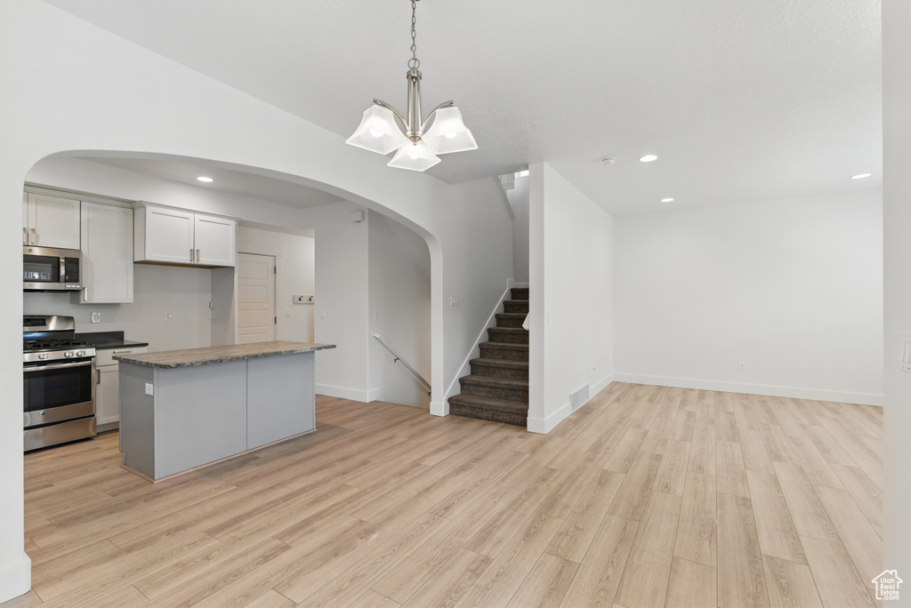 Kitchen with recessed lighting, light wood-type flooring, appliances with stainless steel finishes, and open floor plan