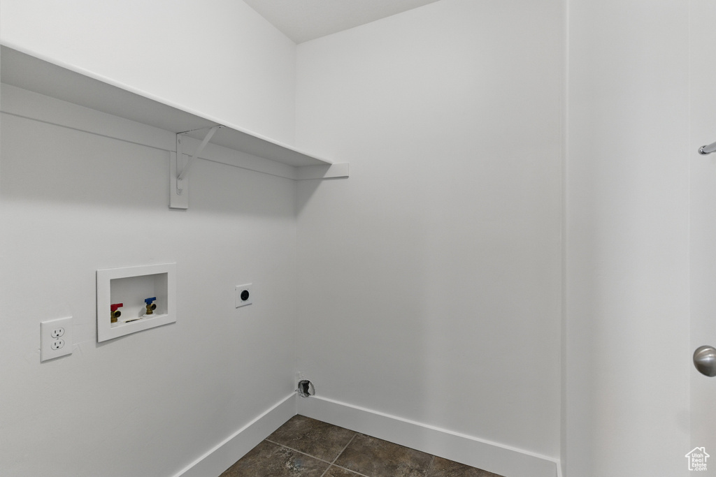 Clothes washing area featuring baseboards, washer hookup, electric dryer hookup, dark tile patterned flooring, and laundry area