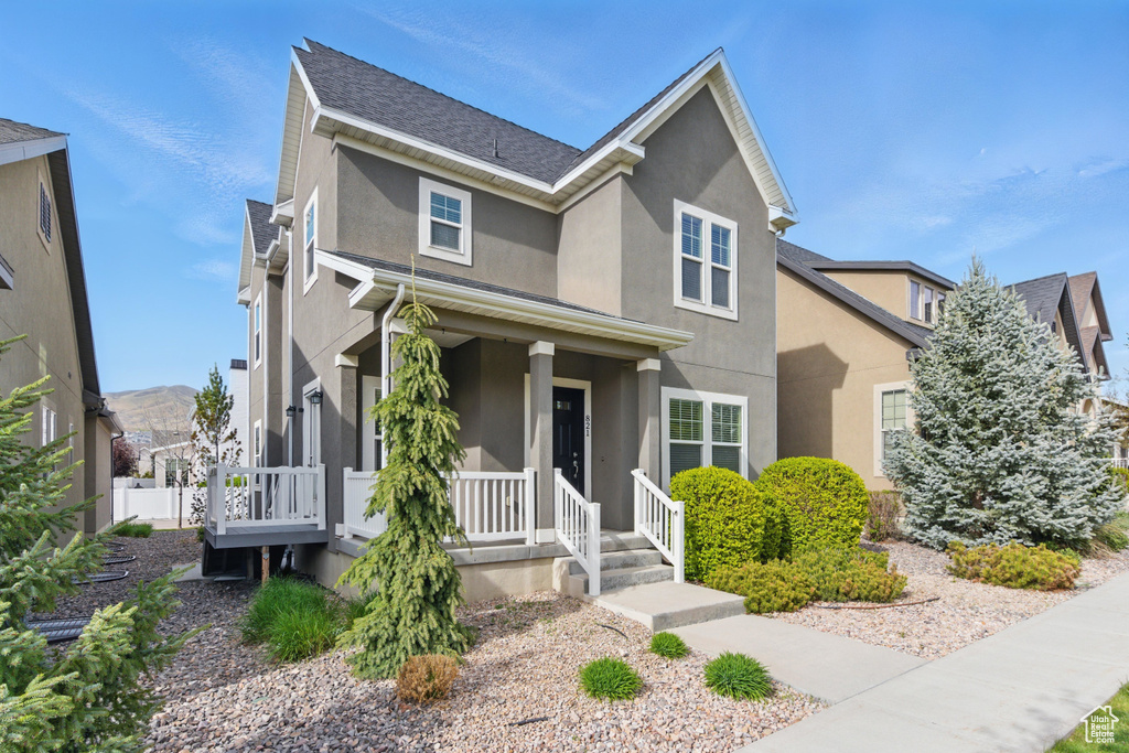 Traditional-style home featuring stucco siding and a porch