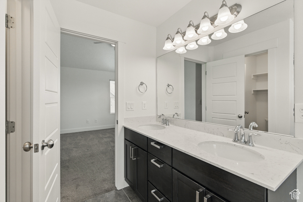 Full bath featuring baseboards, a sink, and double vanity