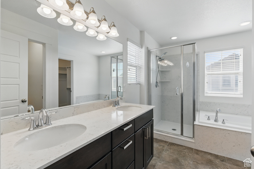 Bathroom with a garden tub, a sink, a shower stall, and double vanity