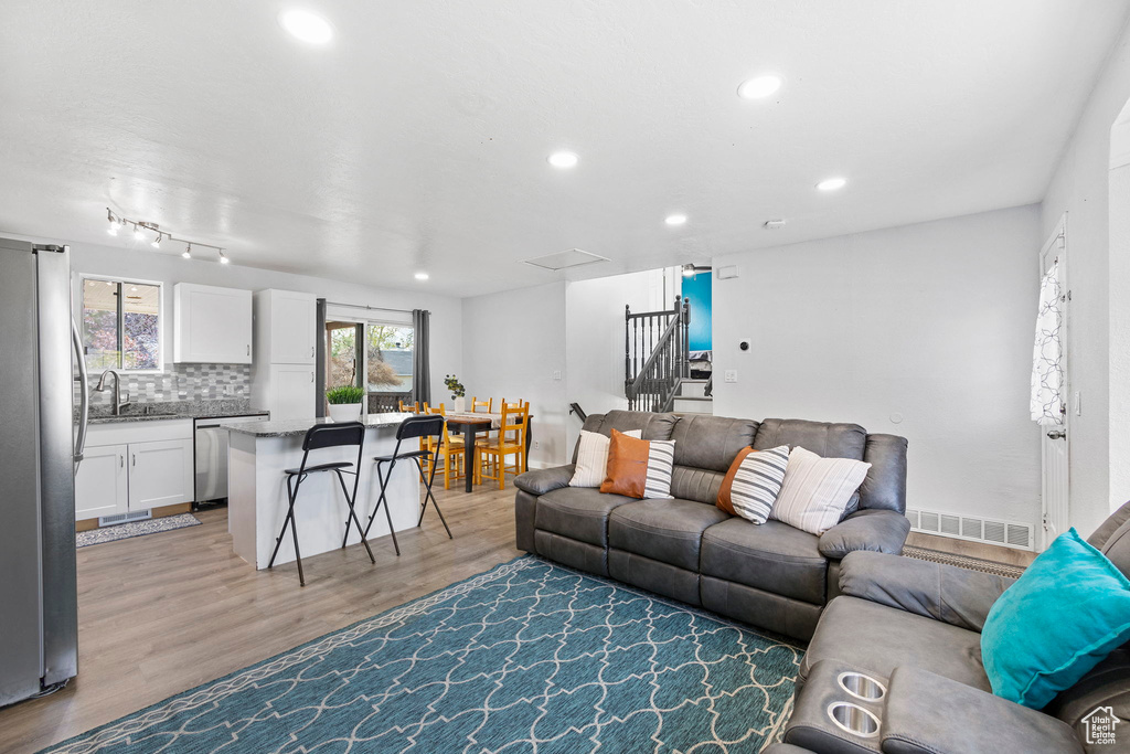 Living area with recessed lighting, light wood-type flooring, and visible vents