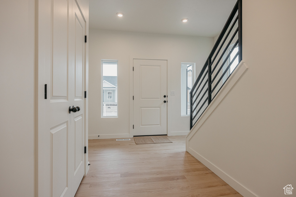 Entrance foyer featuring stairway, baseboards, light wood-style floors, and recessed lighting