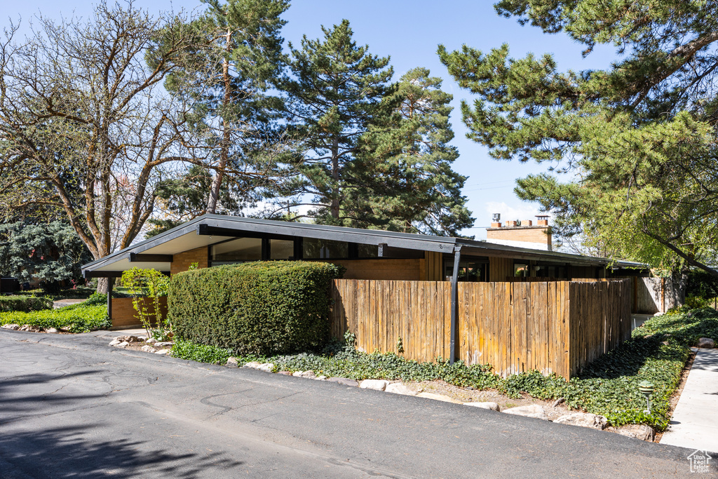 View of side of property featuring brick siding and fence