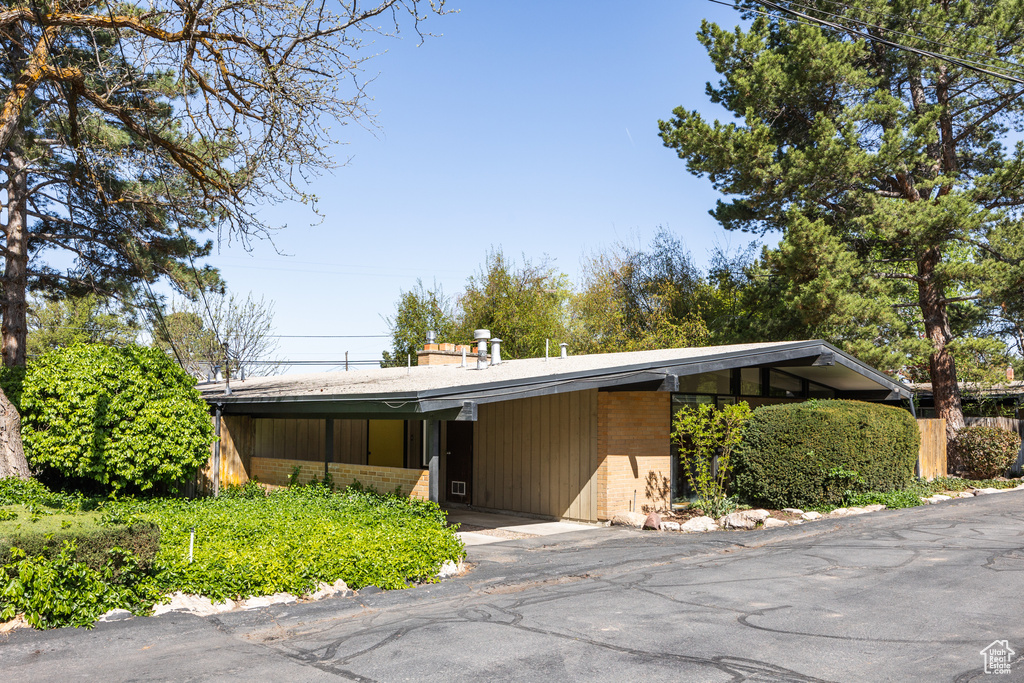 View of front of house with aphalt driveway, an attached carport, and brick siding