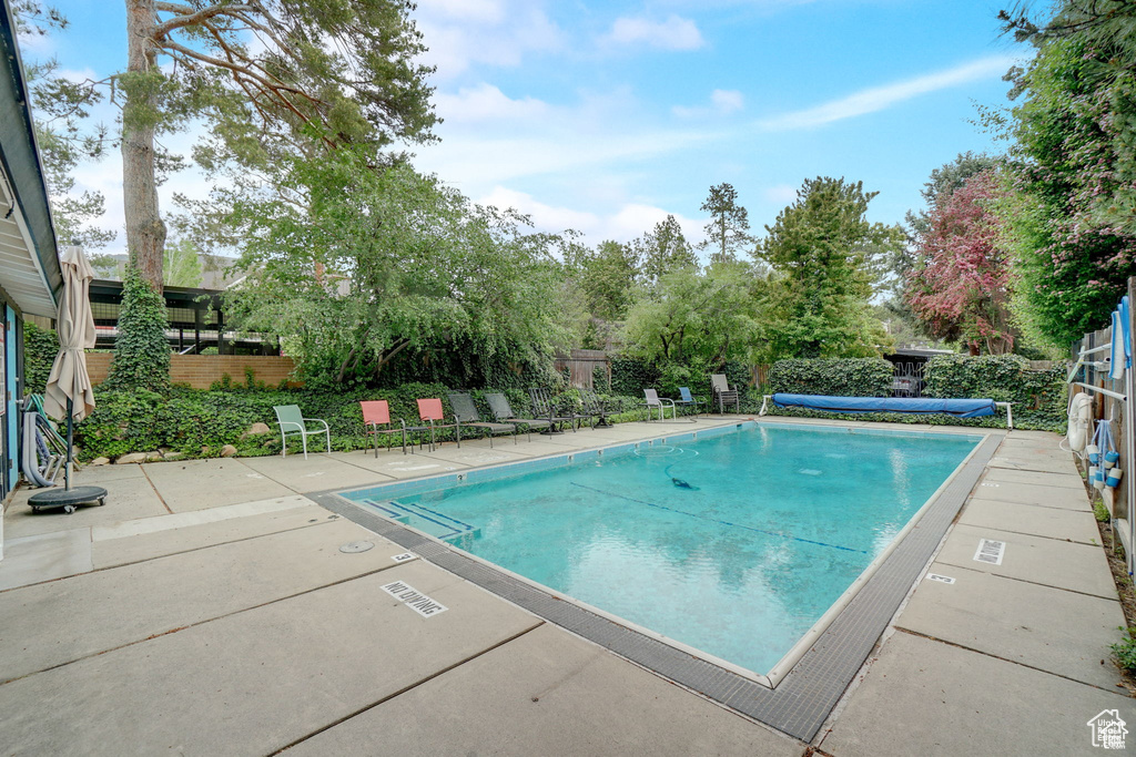 Community pool with fence and a patio area