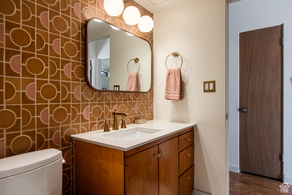 Bathroom featuring wood finished floors, vanity, and toilet