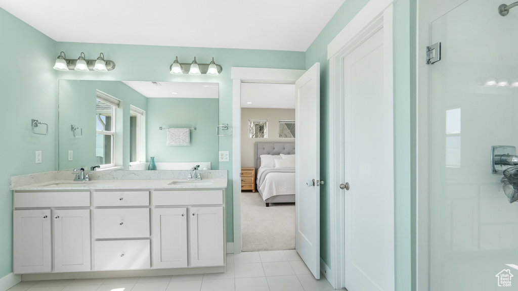 Full bath with tile patterned flooring, a sink, double vanity, and ensuite bathroom