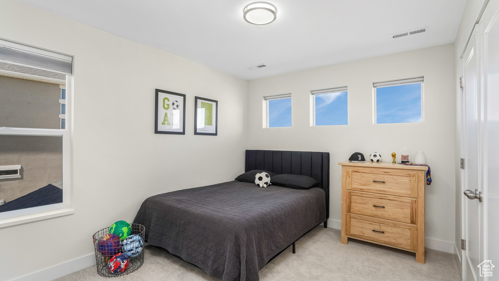 Bedroom featuring light colored carpet, baseboards, and visible vents