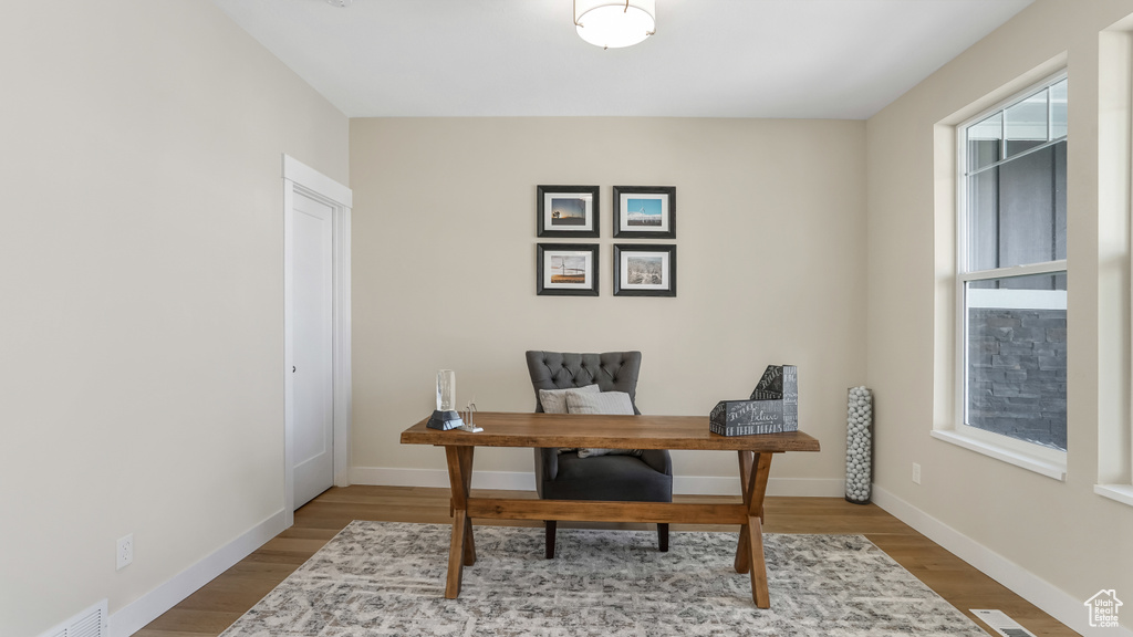 Home office featuring wood finished floors, visible vents, and baseboards