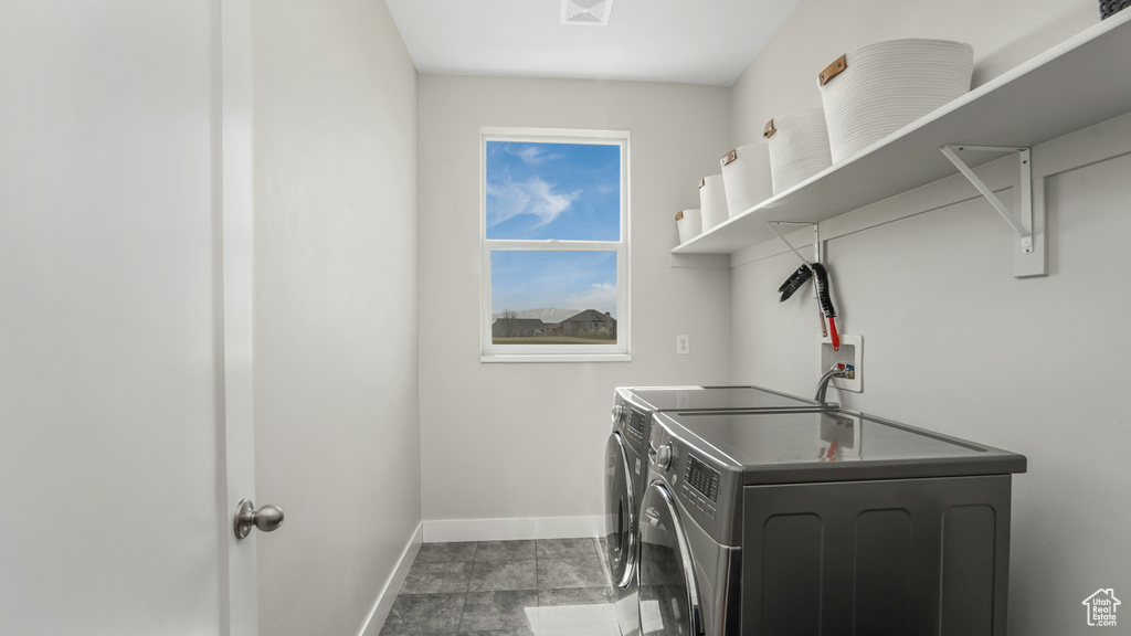 Washroom featuring washer and dryer, baseboards, and laundry area