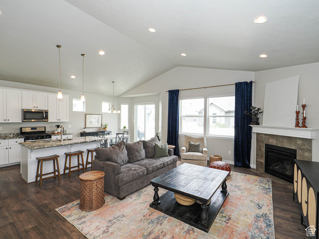 Living room with vaulted ceiling, recessed lighting, and dark wood finished floors
