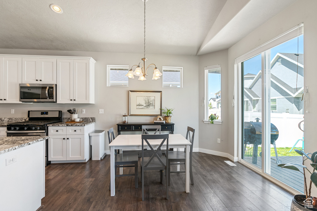 Kitchen featuring appliances with stainless steel finishes, a chandelier, dark wood-style floors, white cabinets, and recessed lighting