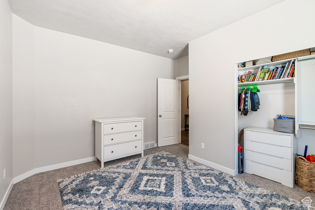 Bedroom with carpet flooring, baseboards, and a closet