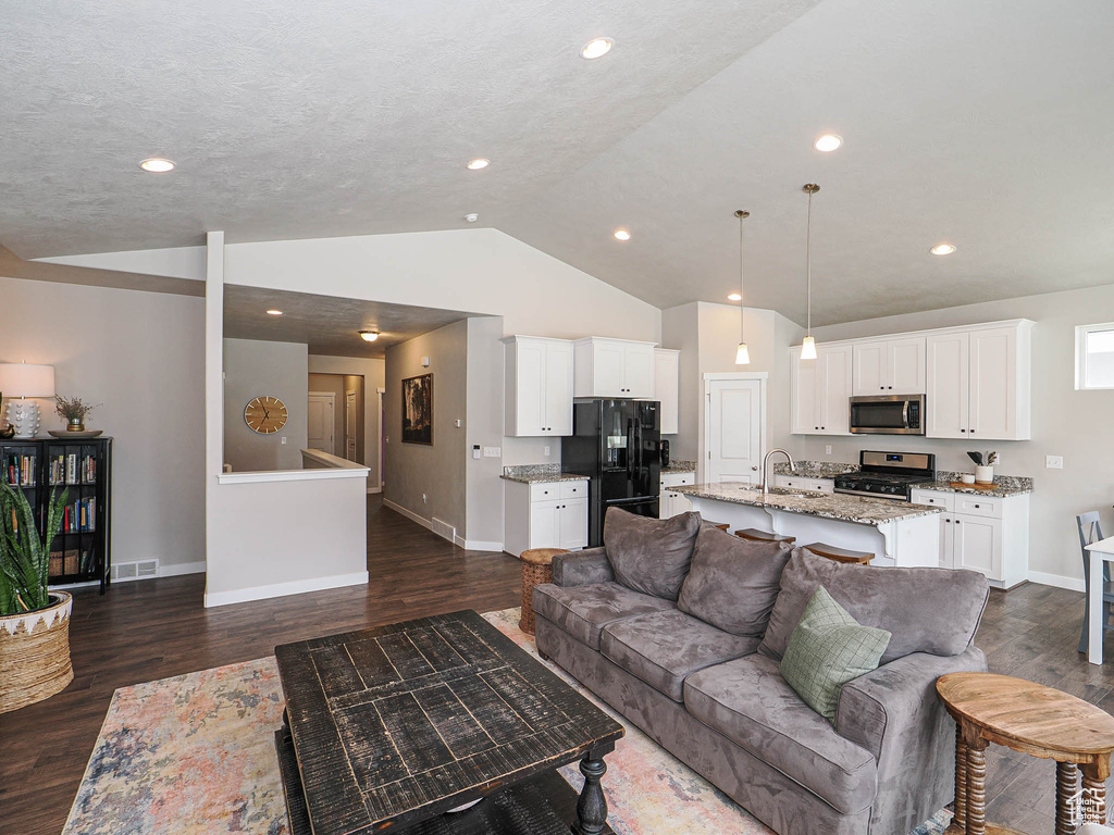 Living room with recessed lighting, dark wood finished floors, vaulted ceiling, visible vents, and baseboards