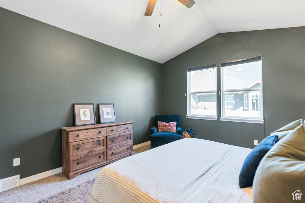 Carpeted bedroom with lofted ceiling, a ceiling fan, and baseboards