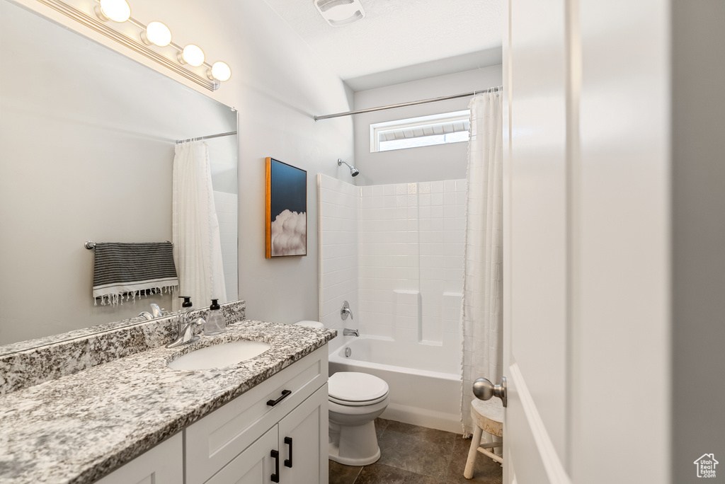 Bathroom with toilet, shower / tub combo, vanity, and tile patterned floors
