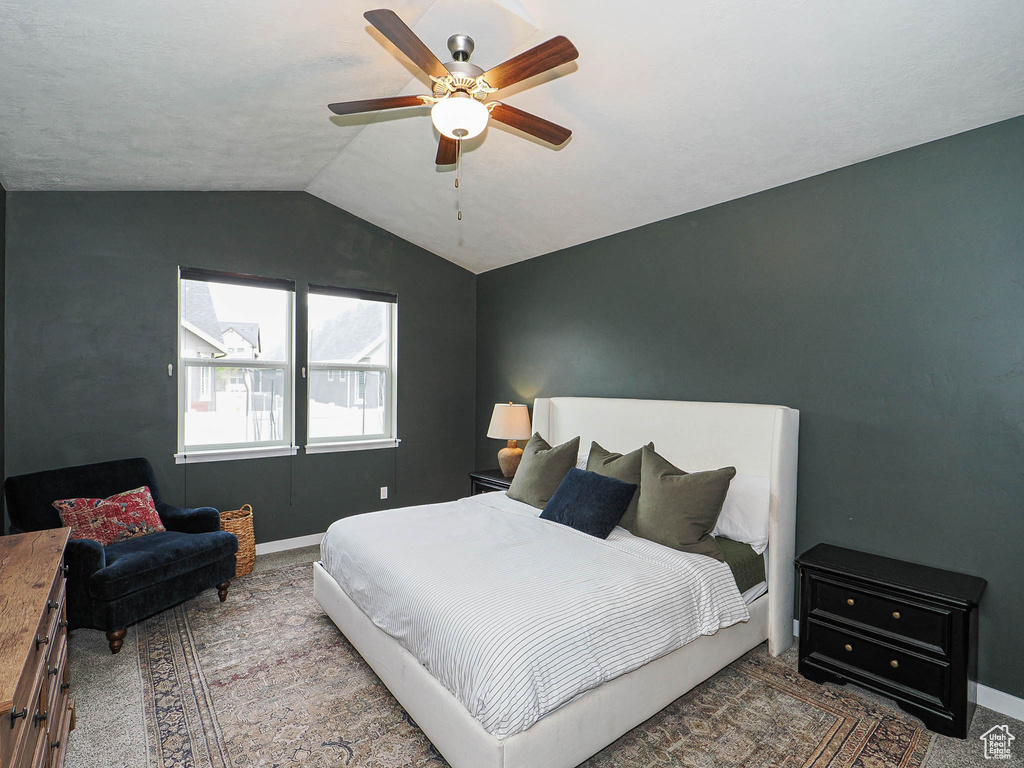 Bedroom featuring lofted ceiling, baseboards, carpet flooring, and ceiling fan