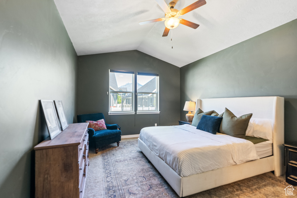 Bedroom featuring carpet flooring, vaulted ceiling, and a ceiling fan