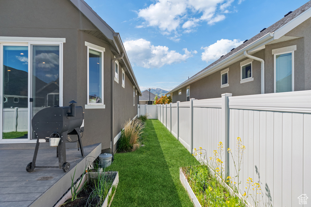 View of property exterior with stucco siding and a deck with mountain view
