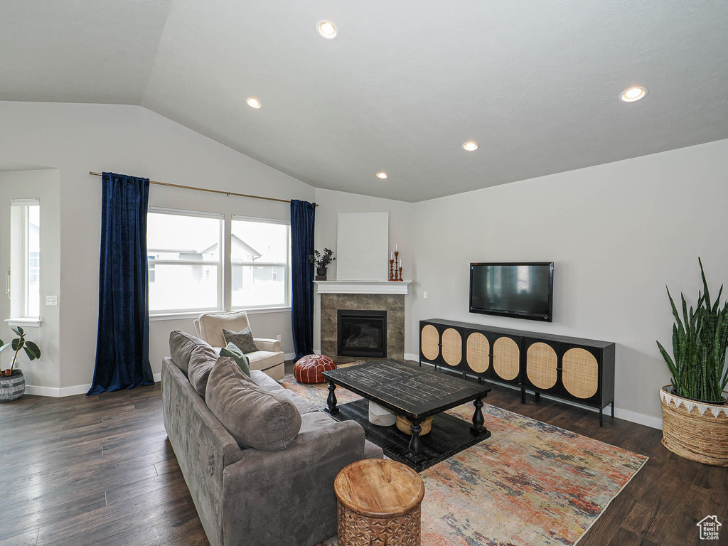 Living room with recessed lighting, vaulted ceiling, baseboards, and wood finished floors
