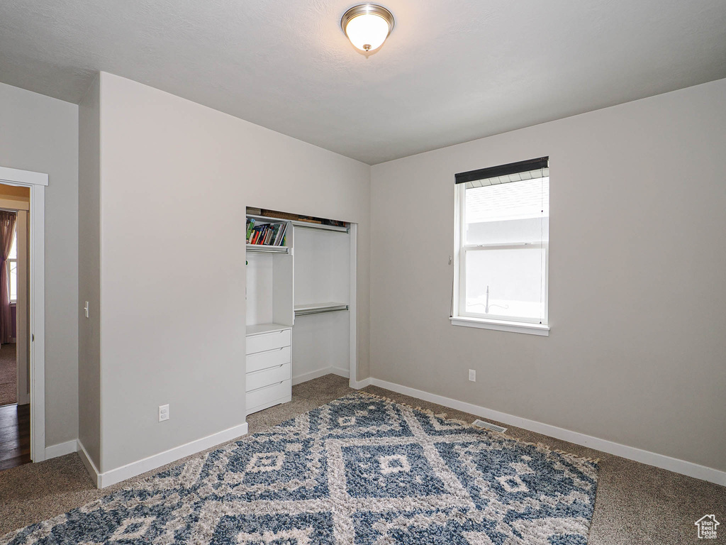Unfurnished bedroom with baseboards, carpet flooring, and a closet