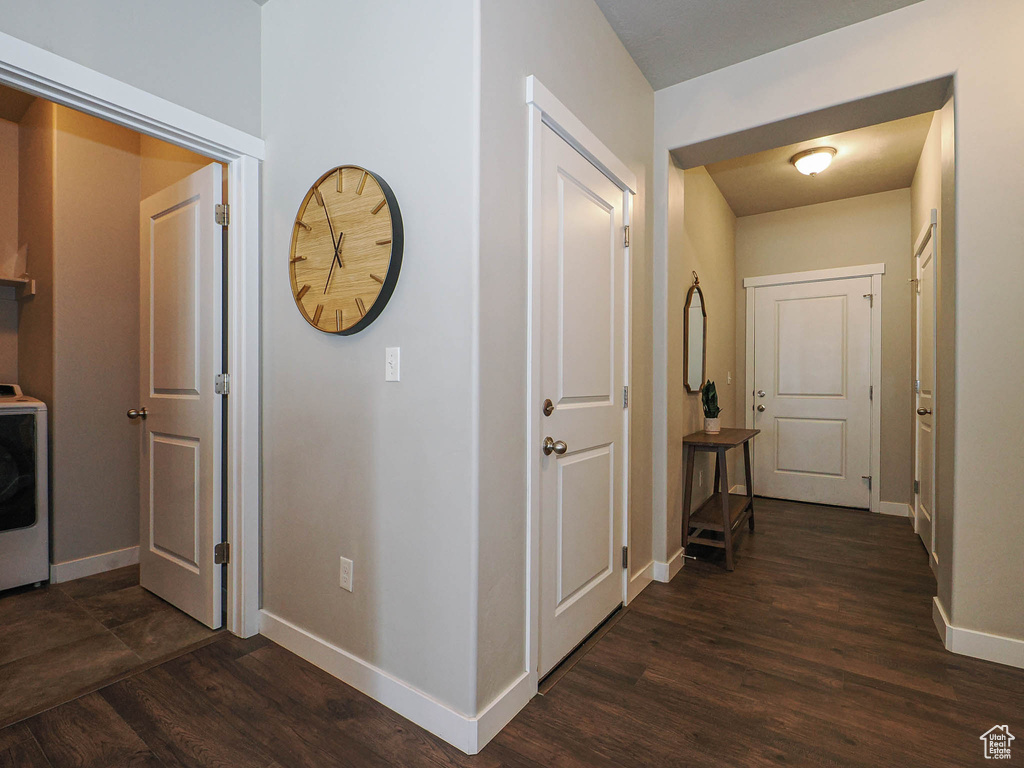 Hall with baseboards, dark wood-type flooring, and washer / clothes dryer