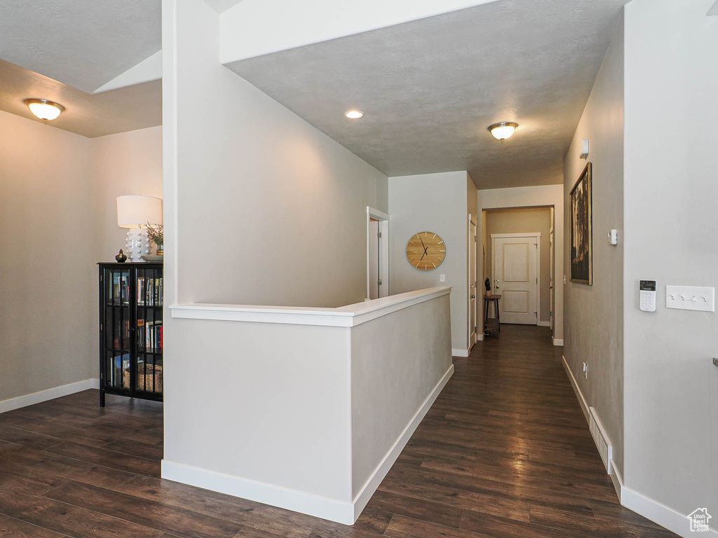 Hall with baseboards, dark wood-style flooring, an upstairs landing, and recessed lighting