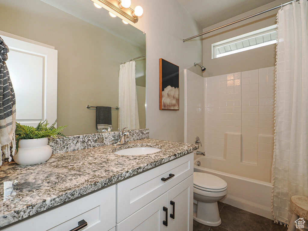 Full bathroom featuring shower / tub combo with curtain, tile patterned flooring, vanity, and toilet