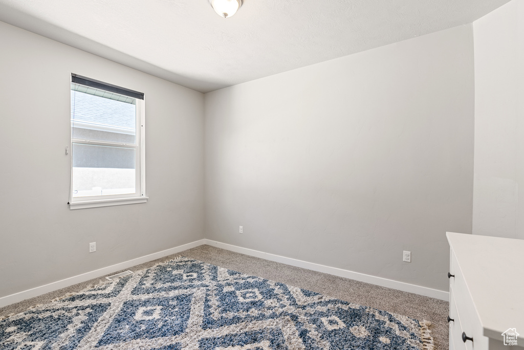 Empty room with baseboards and light carpet