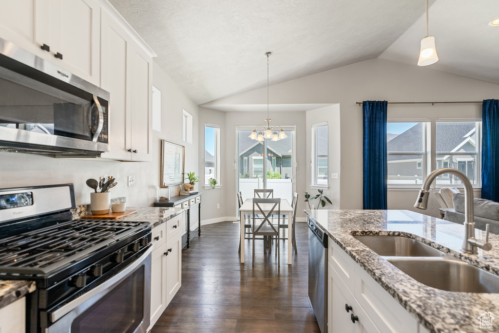 Kitchen featuring stainless steel appliances, a sink, lofted ceiling, a chandelier, and dark wood-style flooring