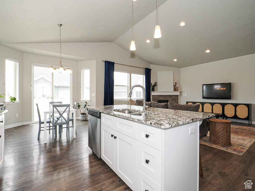 Kitchen featuring vaulted ceiling, stainless steel dishwasher, a sink, a chandelier, and dark wood-style flooring